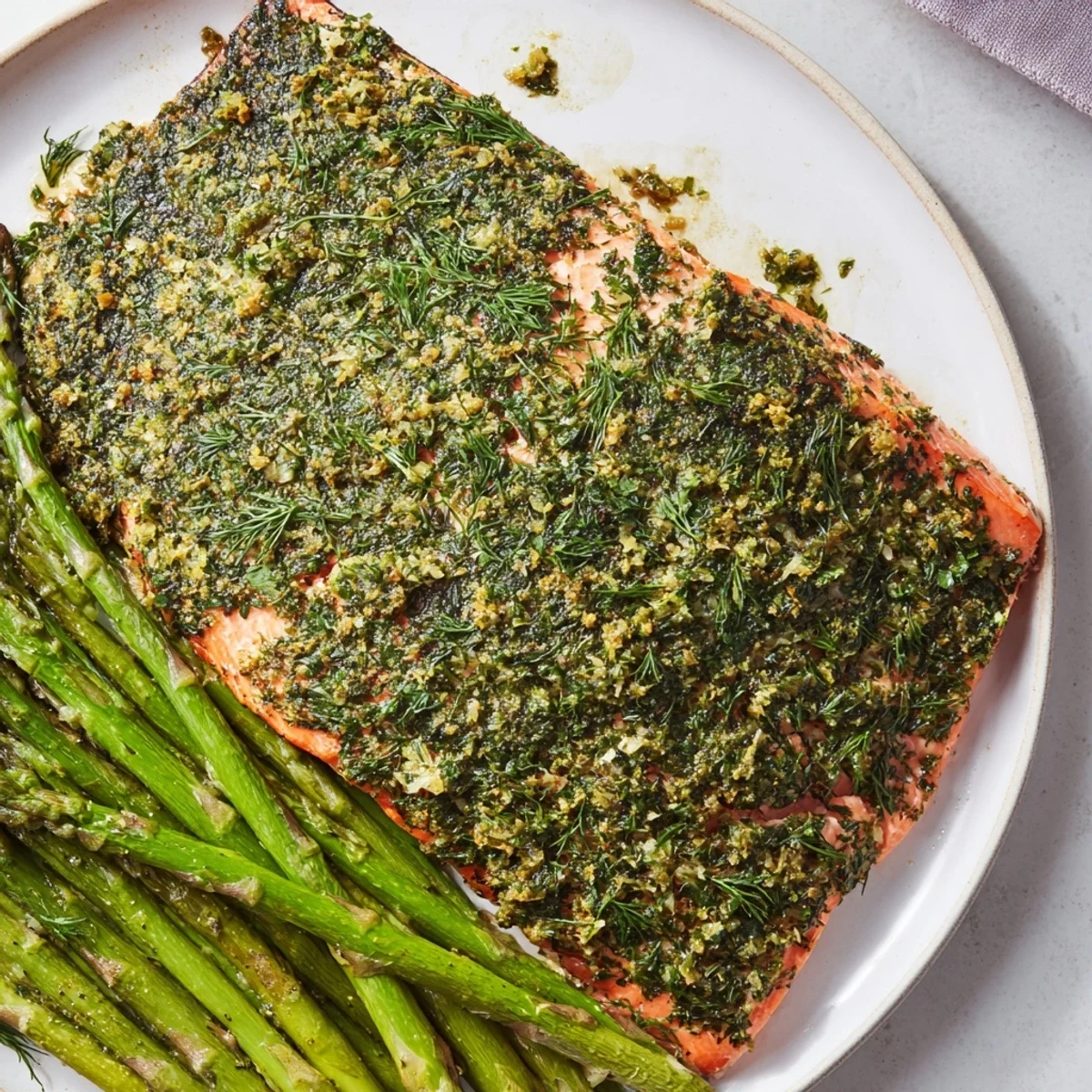 Golden-brown Easy Herb-Crusted Salmon with asparagus, ready to be served with lemon wedges.