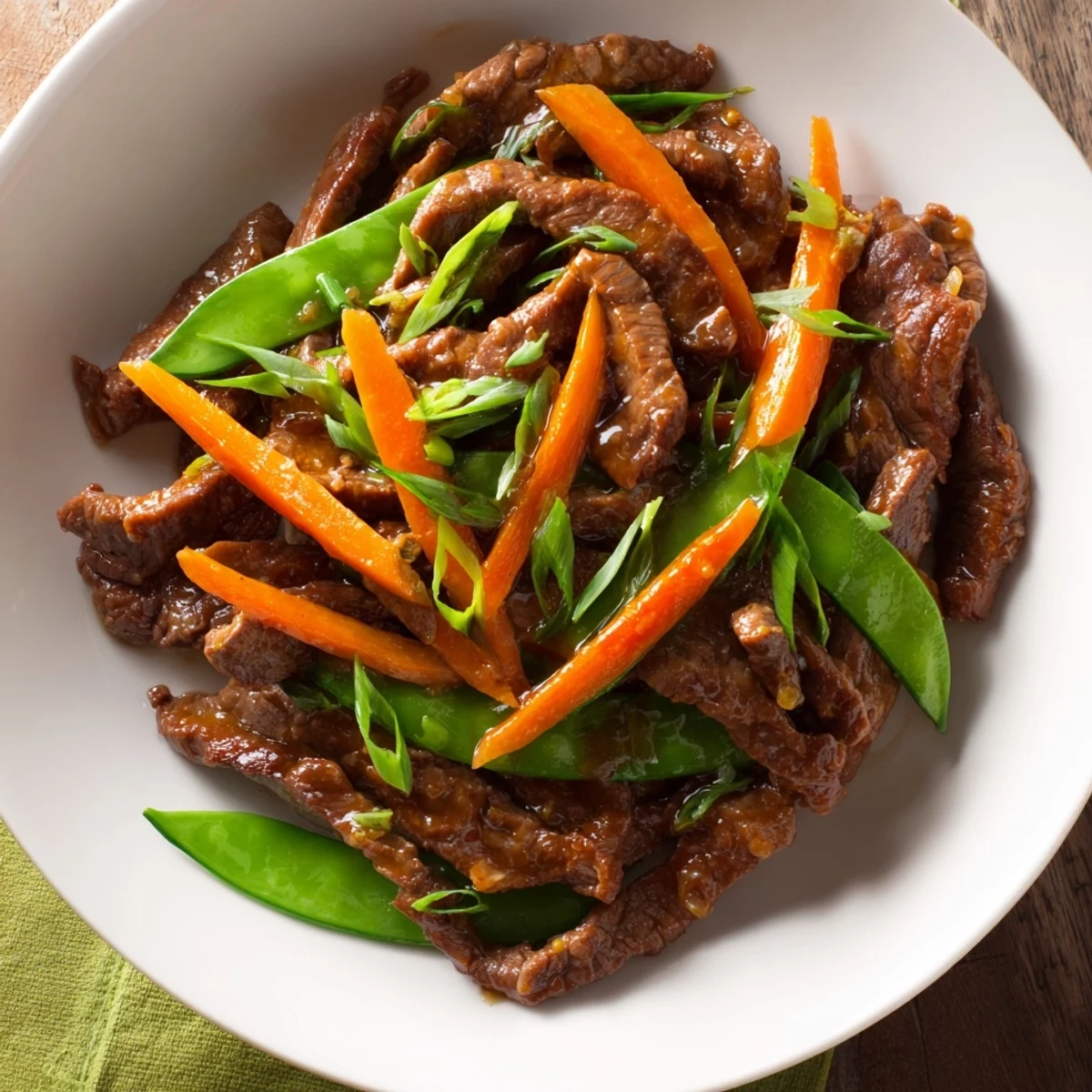 Skillet Beef Stir-Fry with bright snap peas and carrots glistening with a savory sauce, ready to eat.