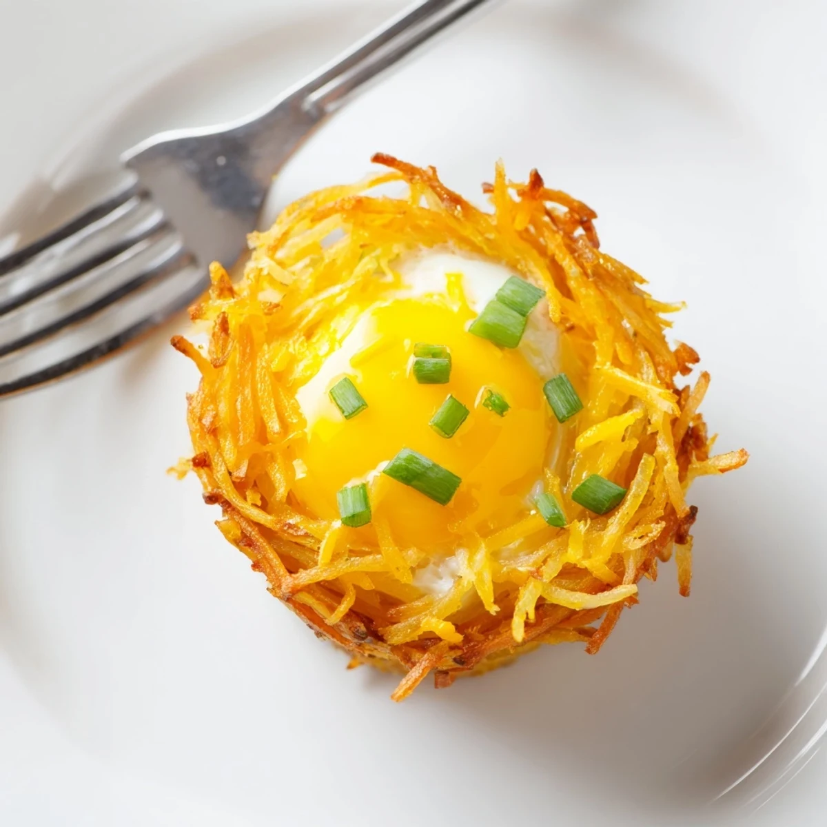 Warm and savory Crispy Hashbrown Egg Nests, baked potato nests filled with eggs, ready to eat.