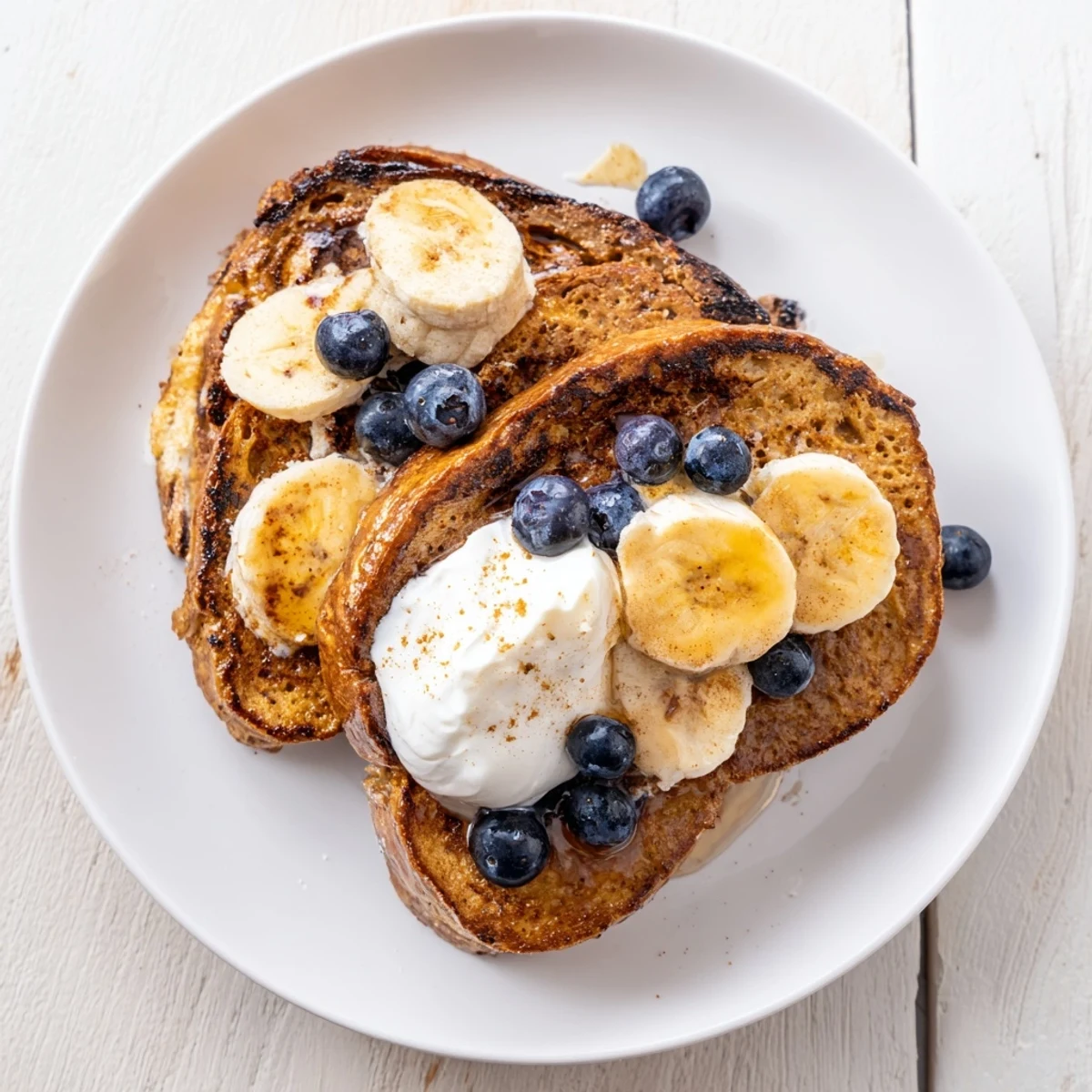 A stack of delicious, custardy Protein French Toast, ready to be drizzled with syrup and enjoyed.