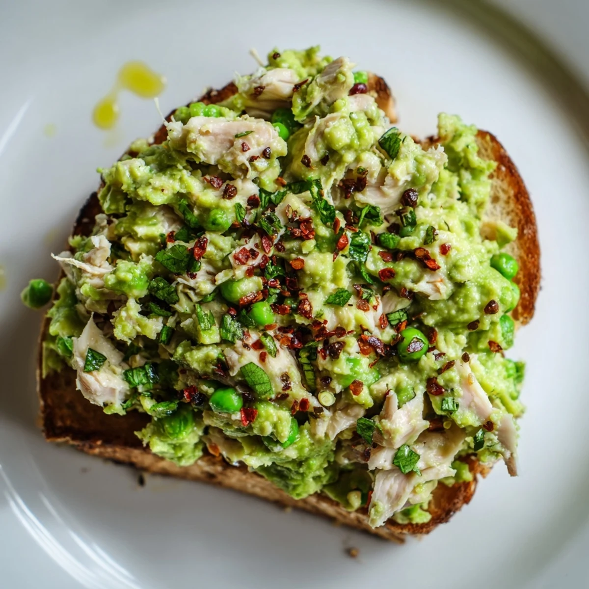 Warm Smashed Pea & Chicken Toast served with crumbled feta and lemony pea spread.