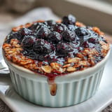 Juicy blueberries bake into comforting single-serve oats, a healthy breakfast option.