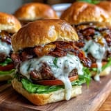 Melted cheddar tops these easy grilled bacon burger sliders, perfect for holidays.