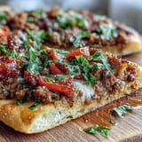 Savory ground lamb topping on thin, crispy Turkish Lahmacun with fresh herbs.