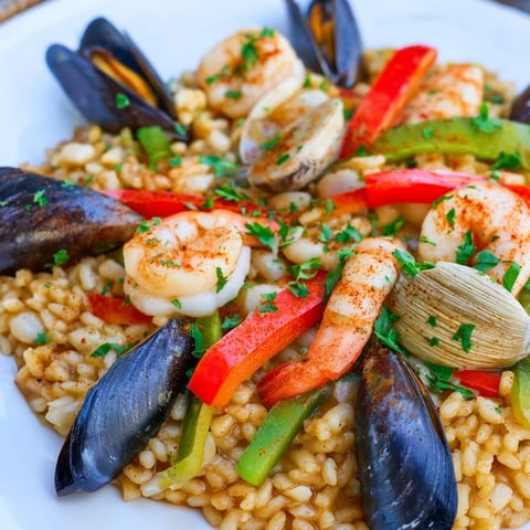 Sizzling Spanish Seafood Paella with colorful bell peppers, rice, and glistening seafood, ready to serve.