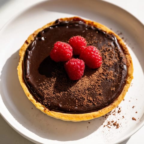 A slice of decadent Dark Chocolate Brownie Tart, inviting with its rich, dark color and textures.