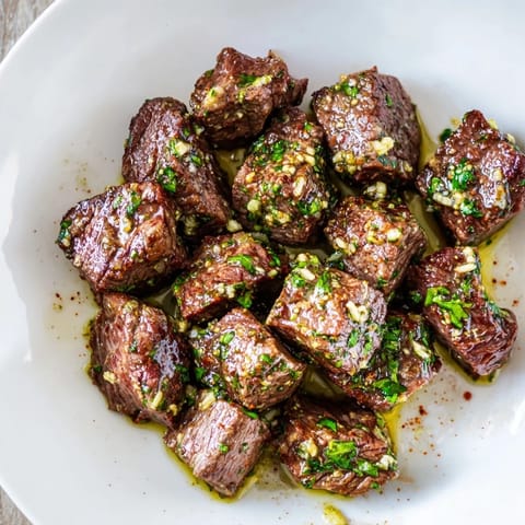 These air-fryer garlic-butter steak bites, cooked with herbs, boast a rich garlic-butter sauce for flavor.