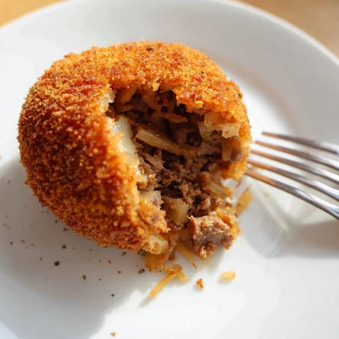 A close-up shows the rich, creamy interior of these homemade Dutch croquettes with beef.