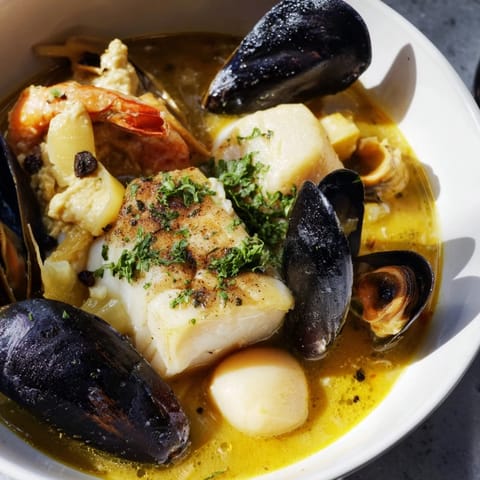 The aromatic bouillabaisse, brimming with fish and shellfish, is served with toasted baguette slices for dipping.