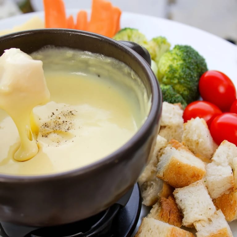 A bubbling pot of Swiss cheese fondue, a flavorful, melted cheese delight for sharing.