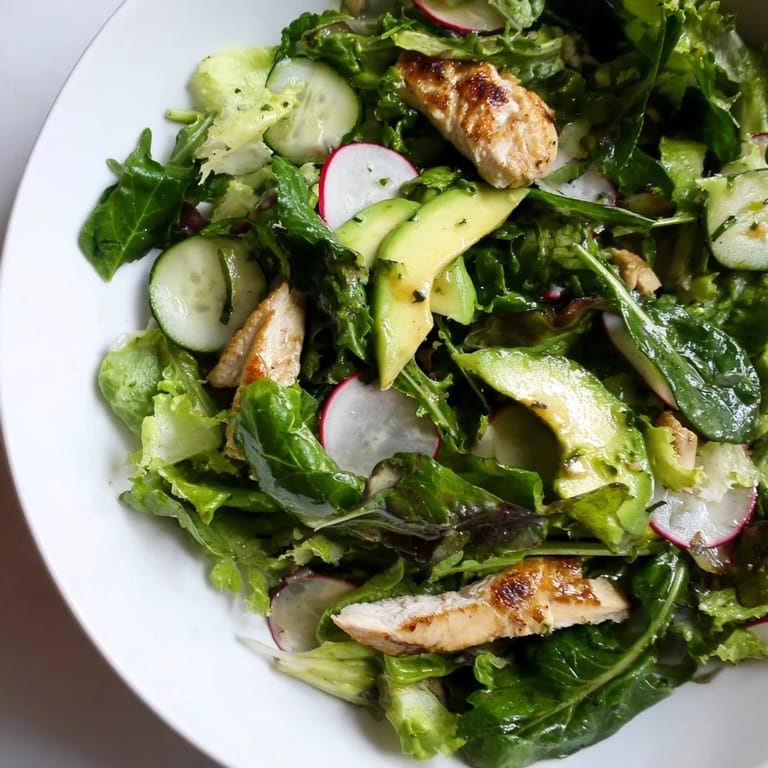 A plated serving of Spring Detox Chicken Salad showcases juicy chicken, crunchy radishes, and greens, with lemon wedges for a fresh, detox-inspired spring lunch.
