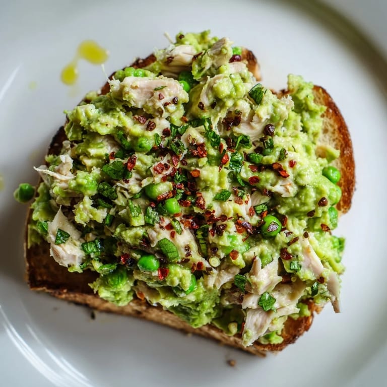Warm Smashed Pea & Chicken Toast served with crumbled feta and lemony pea spread.