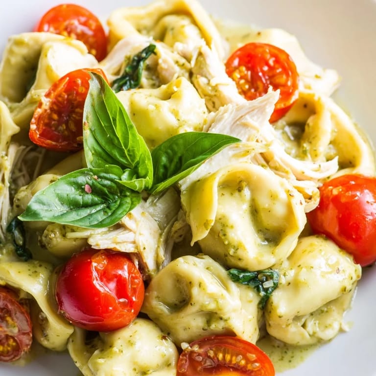 Creamy Pesto Tortellini Skillet served steaming hot, topped with Parmesan and wilted spinach leaves.