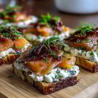 Cucumber Bites with Cream Cheese and Smoked Salmon arranged on a platter with fresh dill and capers.