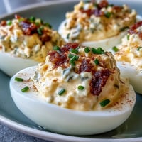 Creamy sweet pickle relish deviled eggs garnished with paprika and chives.